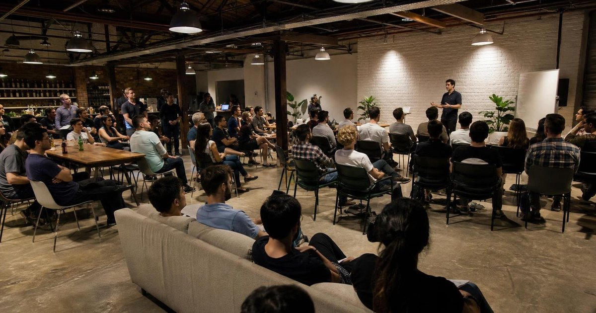 Small Australian startup meetup group chatting in a casual workspace during an active community event