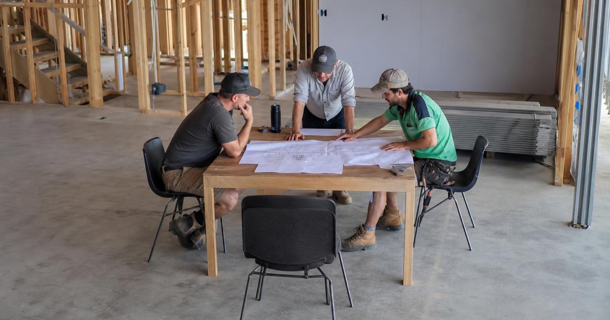 Team reviewing AI adoption numbers on laptops during a candid office planning session