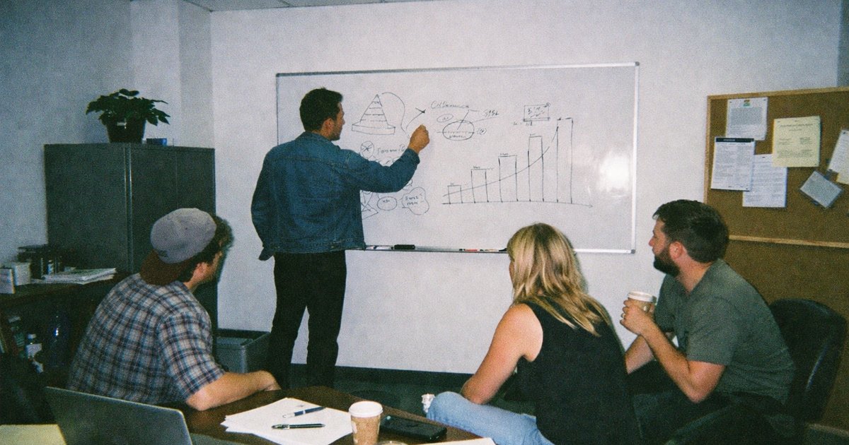 People collaborating in a tech startup workspace, captured in a vibrant 90s film aesthetic.
