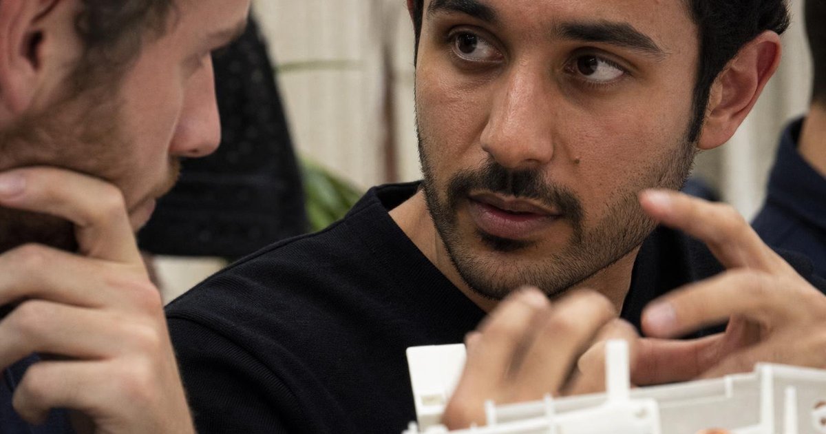 Founders reviewing product evidence on a laptop, hand gesturing at an Australian startup meetup