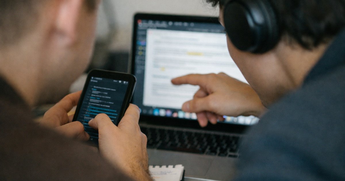 Ultra-close candid of a hand guiding AI agent workflow on laptop, comparing assistants, bots