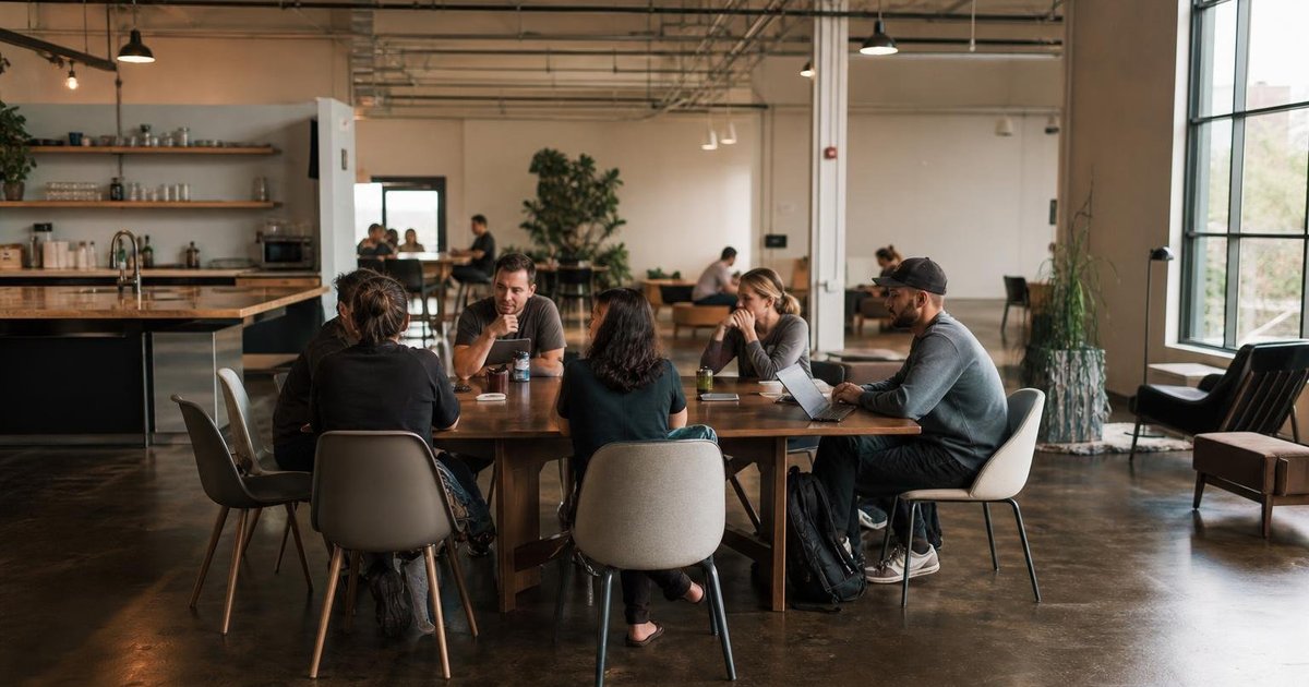 Startup founders reviewing product metrics and market notes together in a candid office meeting