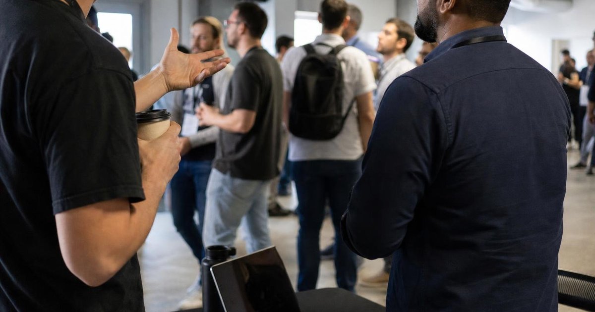 Laptops, name badges and coffee cups at a candid Australian tech meetup networking table