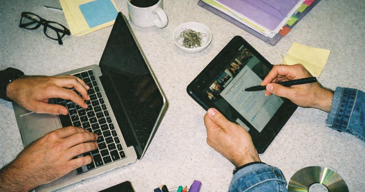 Diverse team collaborating in a vibrant 90s tech startup setting, surrounded by laptops and creative brainstorming.