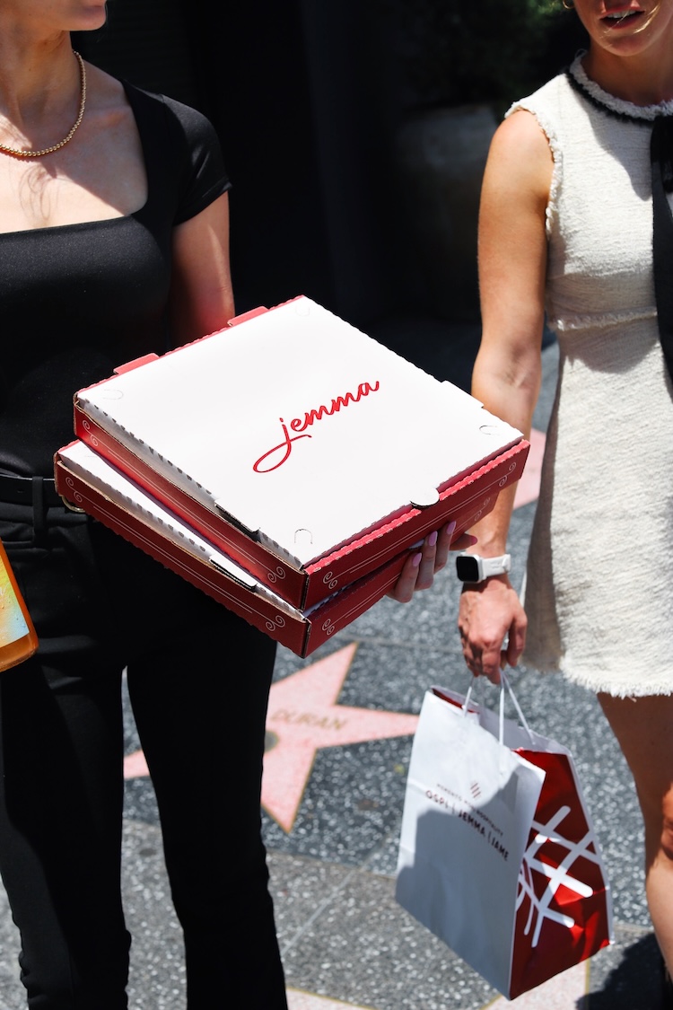 Jemma-branded pizza box being carried.