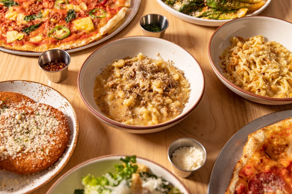 Several dishes served family style on a wooden table.