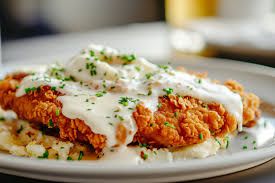 Golden chicken fried steak with creamy gravy, evoking a warm, comforting Texas dining experience.