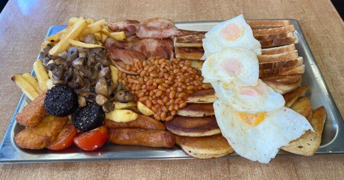 A hearty Ulster Fry breakfast, sunlit, evoking Belfast's hidden culinary secrets.