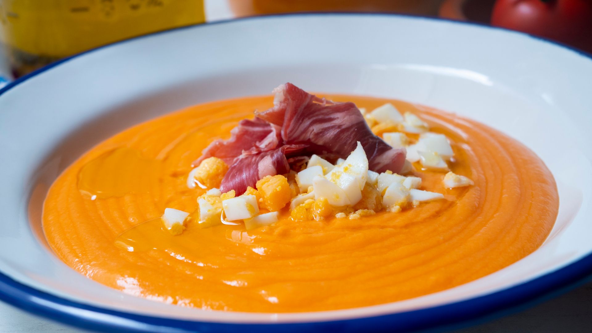 Vibrant bowl of creamy Salmorejo soup in sun-drenched Seville, a taste of authentic Andalusian tradition.