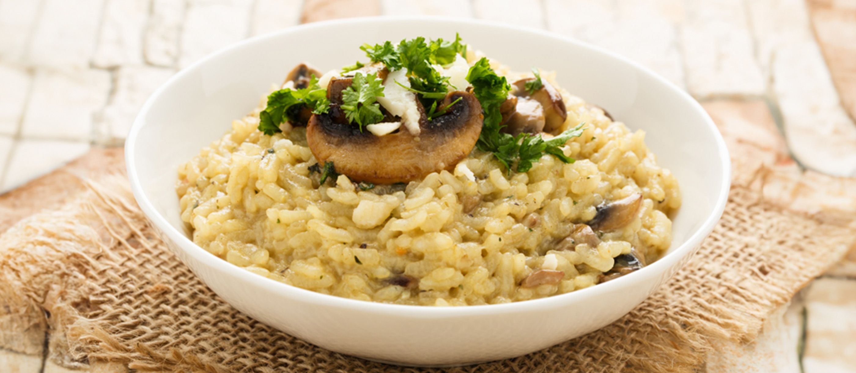 A steaming bowl of creamy porcini mushroom risotto, a hidden Ticino culinary secret, bathed in warm, inviting light.