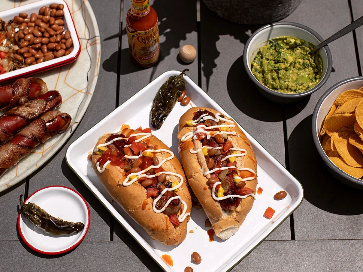 Vibrant Sonoran hot dog feast, lively Gilbert AZ dining scene, sun-kissed flavors.