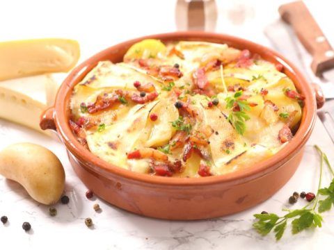 Cozy Chamonix mountain lodge, rustic tartiflette, inviting French Alps dining ambiance.