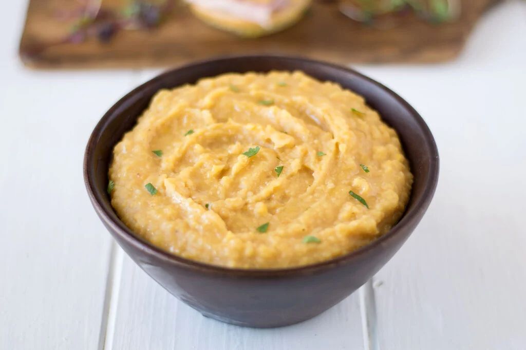 Hearty, golden pease pudding served in a rustic bowl, evoking Newcastle's warm, traditional food heritage.