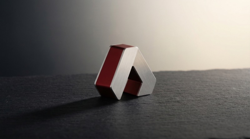 Abstract metallic geometric logo on dark surface