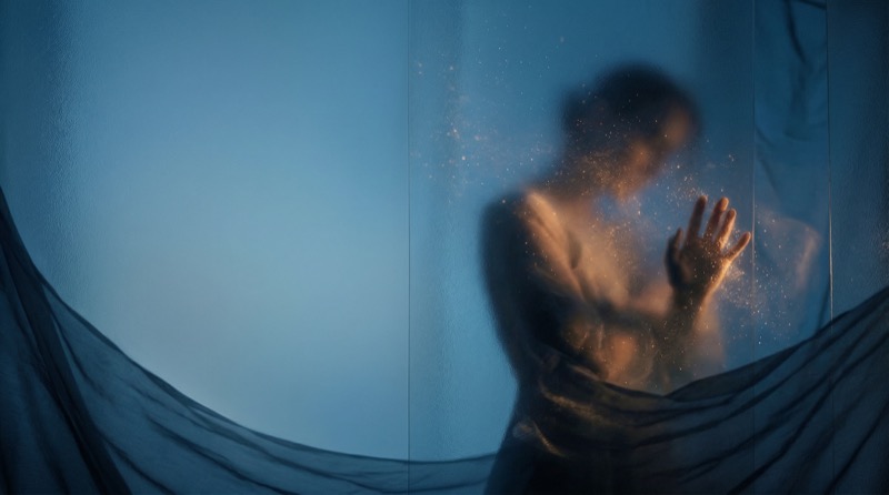 Abstract silhouette behind frosted glass with hand