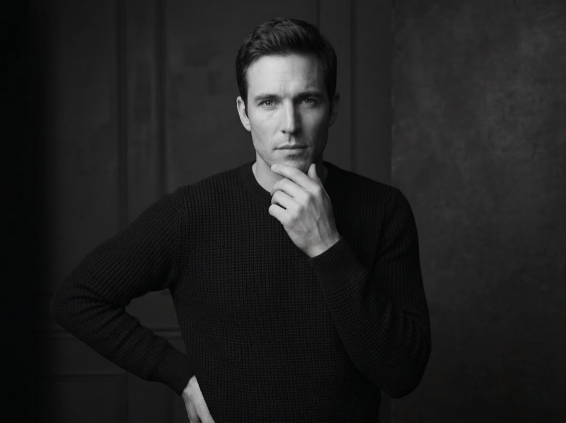 Black and white studio portrait of thoughtful man