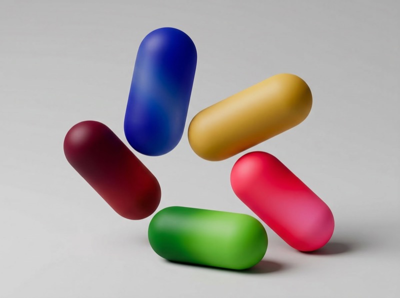 Colorful 3D capsule pills on gray background