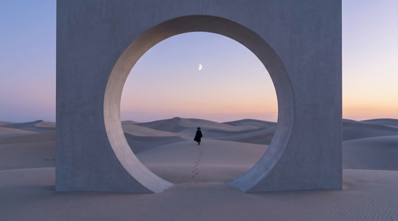 Lone figure in desert framed by circular portal