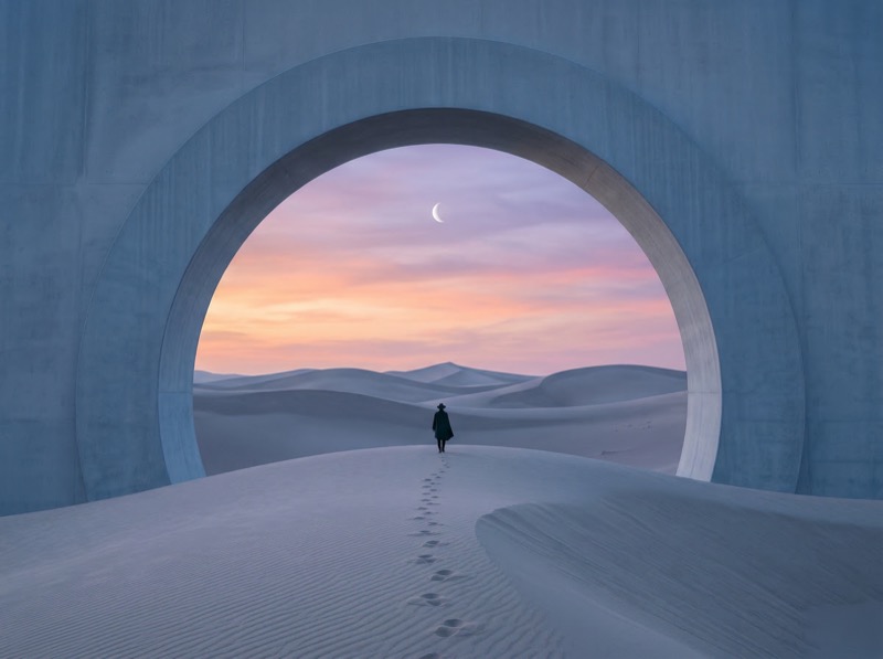 Lone traveler in desert arch at twilight