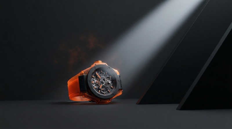 Luxury skeleton watch with orange strap in spotlight