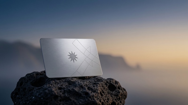 Minimal metallic card on rock at sunrise