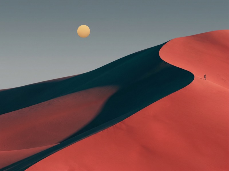 Minimalist desert dunes with lone figure and sun