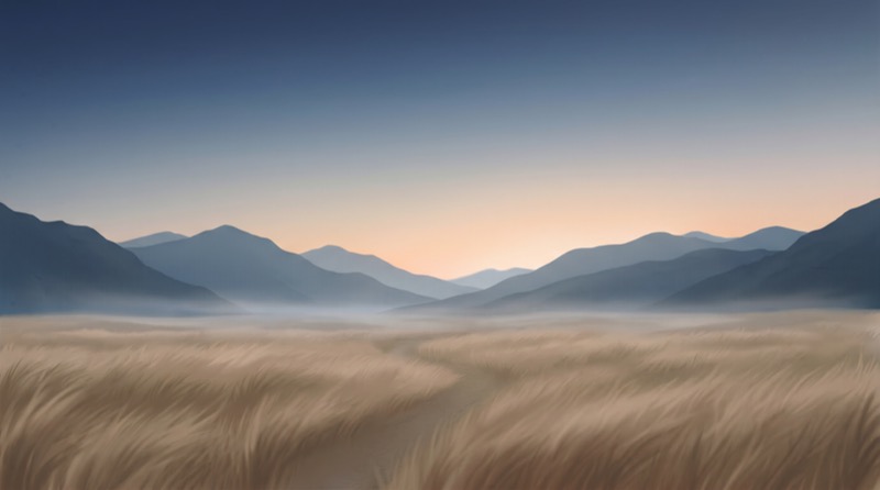Misty Mountain Range at Sunrise Over Grassland
