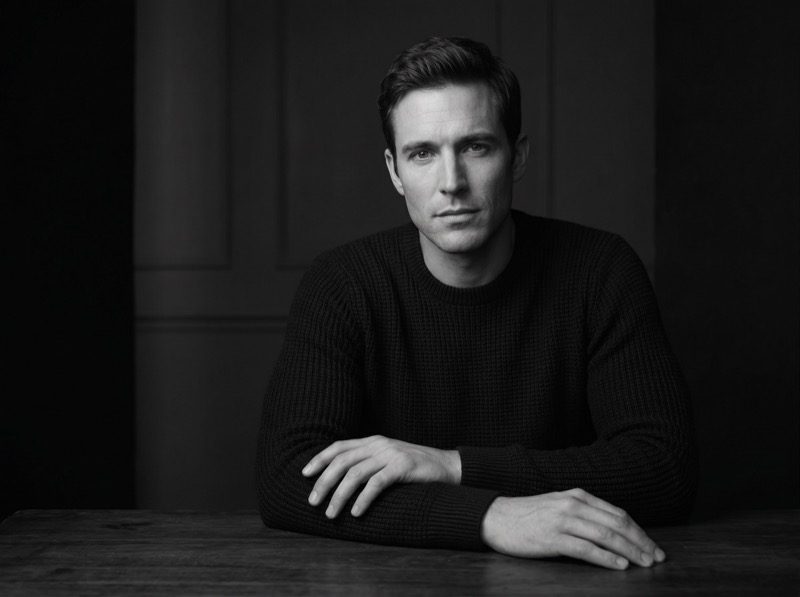 Moody black-and-white portrait of man at table