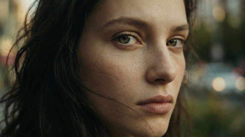 Moody close-up portrait with city bokeh