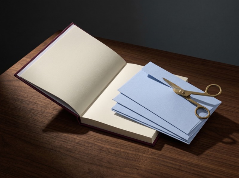 Open blank notebook with envelopes and scissors