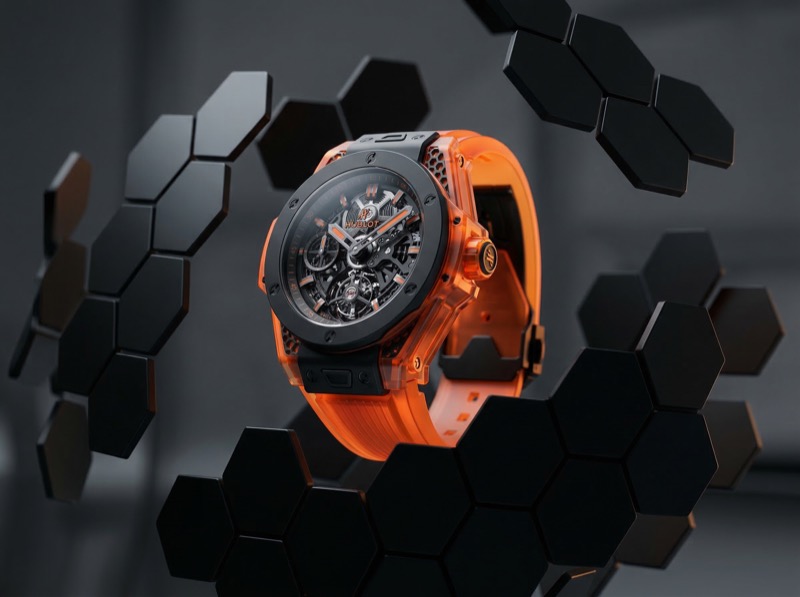Orange skeleton luxury watch with hexagon backdrop