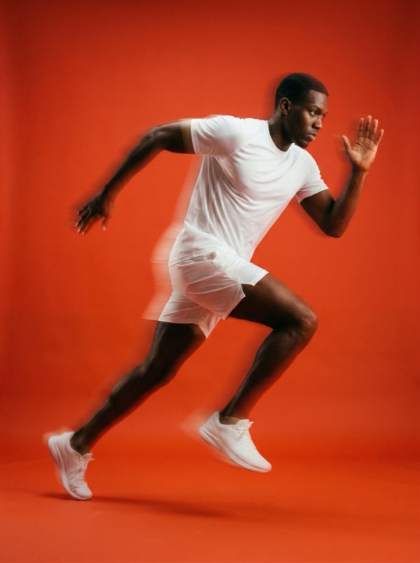 Runner sprinting in studio on red background