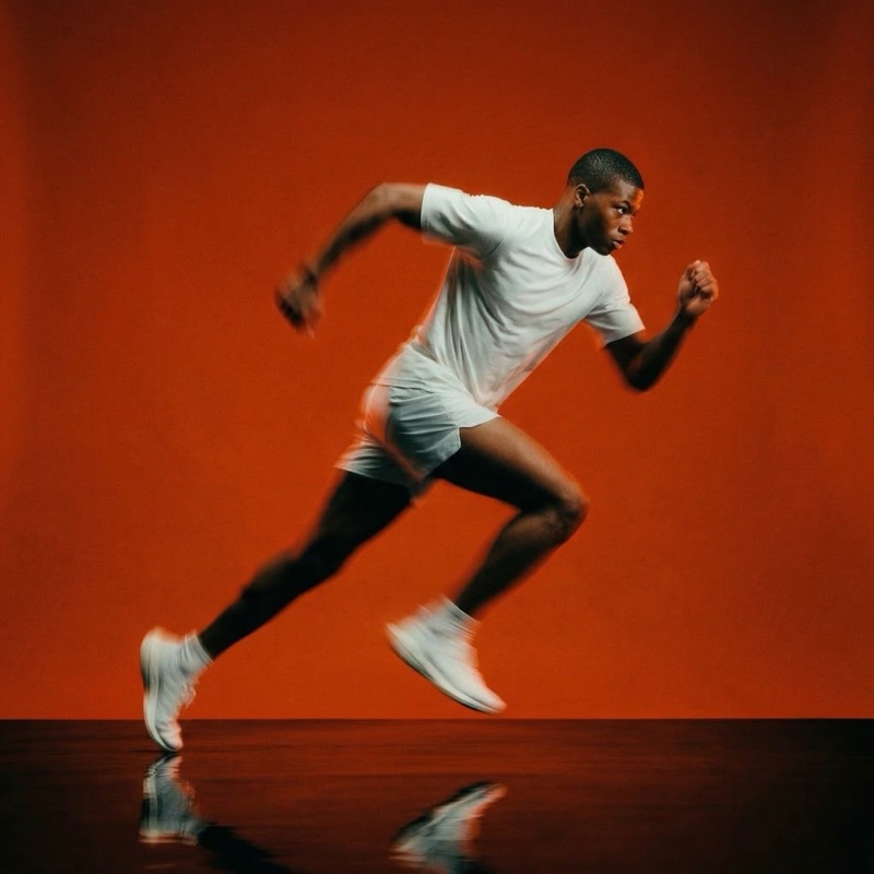 Runner sprinting in studio with orange backdrop