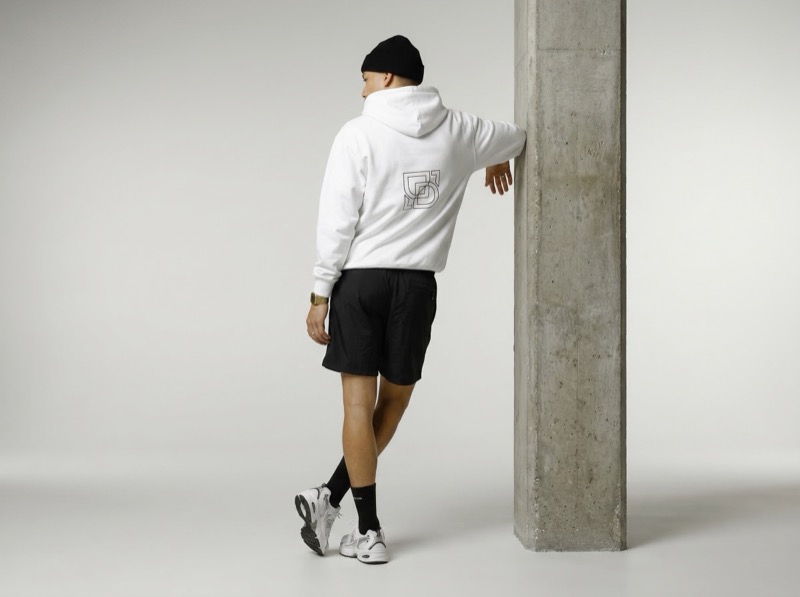 Streetwear model leaning on concrete pillar