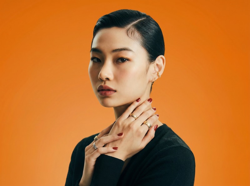 Studio portrait with gold jewelry on orange backdrop