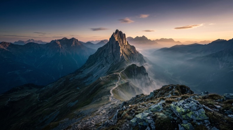 Sunrise over misty mountain ridge trail