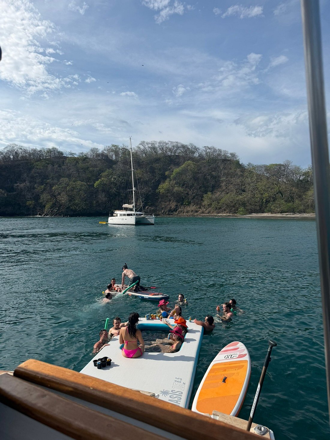 Guests relaxing and swimming near the floating platform and paddleboards