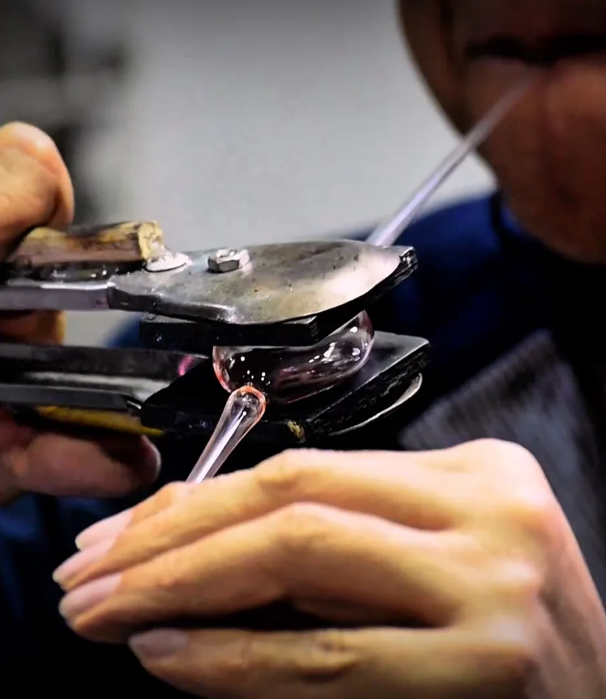 artesano trabajando vidrio soplado para joyería artesanal en Colombia