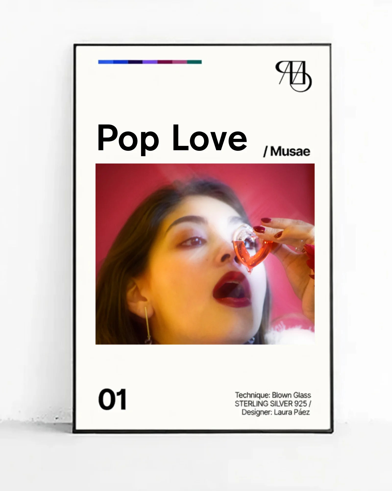 Catalog cover for the "Pop Love / Musae" jewelry collection. Artistic photograph of a woman with brown hair and bold red lipstick holding a transparent red-orange blown glass heart near her eye against a vibrant red background. Minimalist design with bold black typography, number 01, and credits to designer Laura Páez.