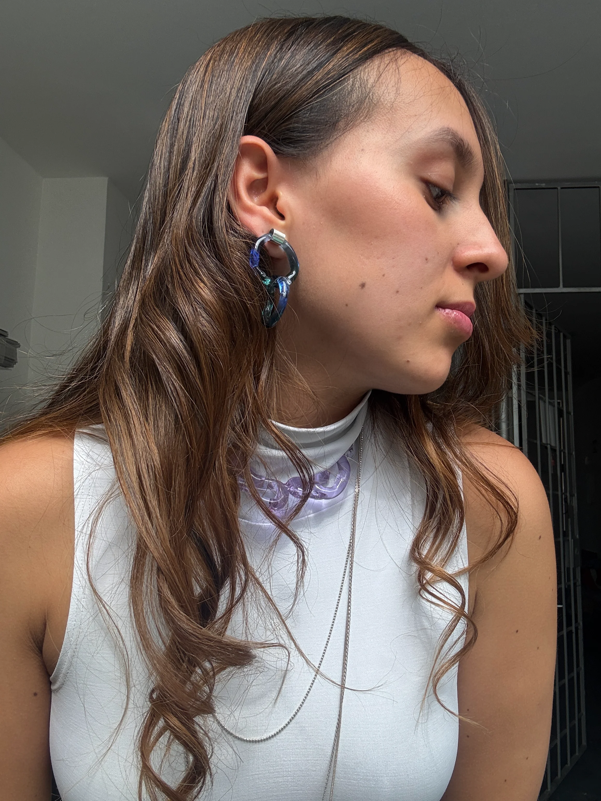 Retrato editorial de una mujer usando joyería artesanal de vidrio colorido