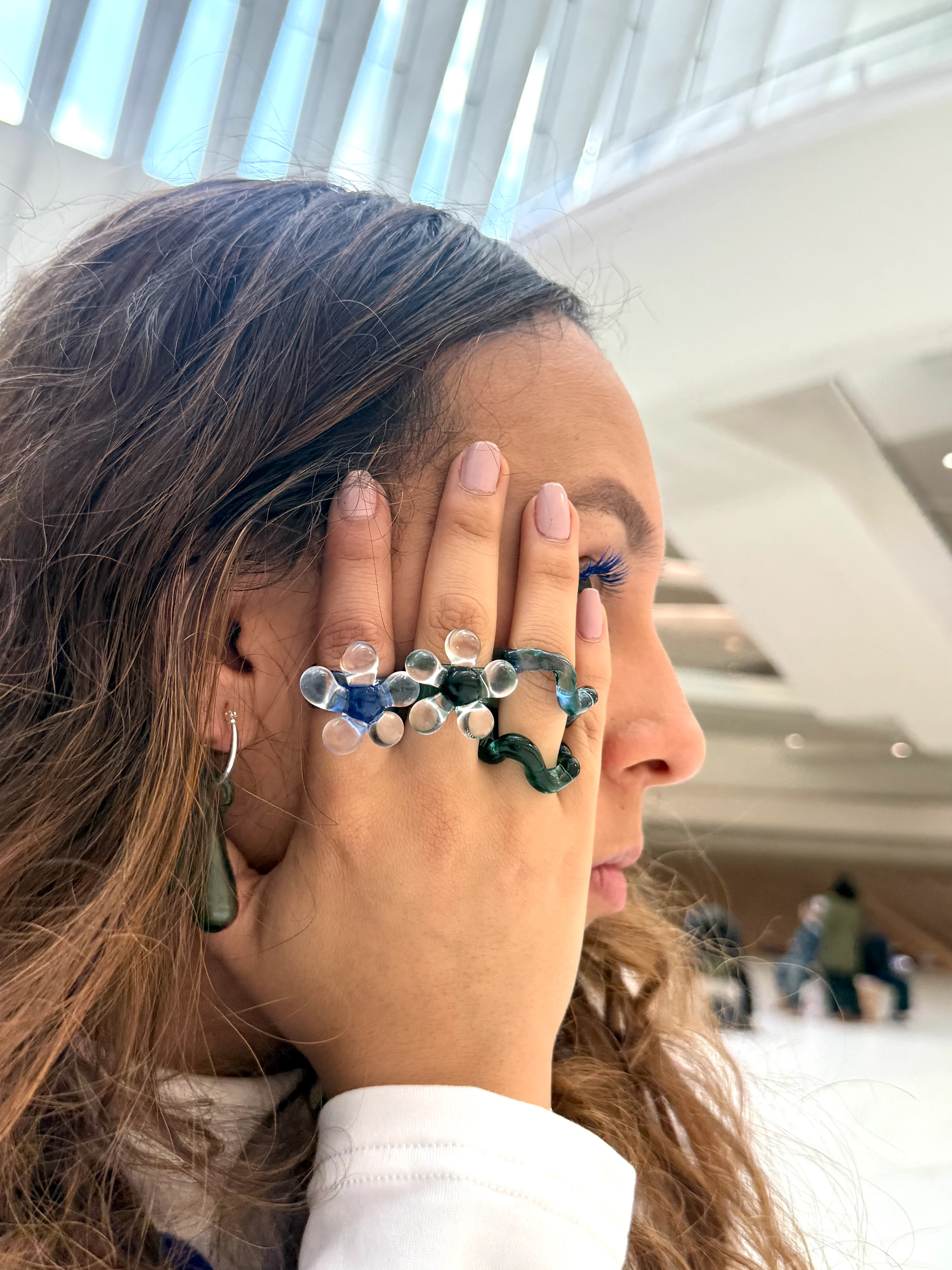 Persona usando aretes de vidrio colombianos hechos a mano con luz natural