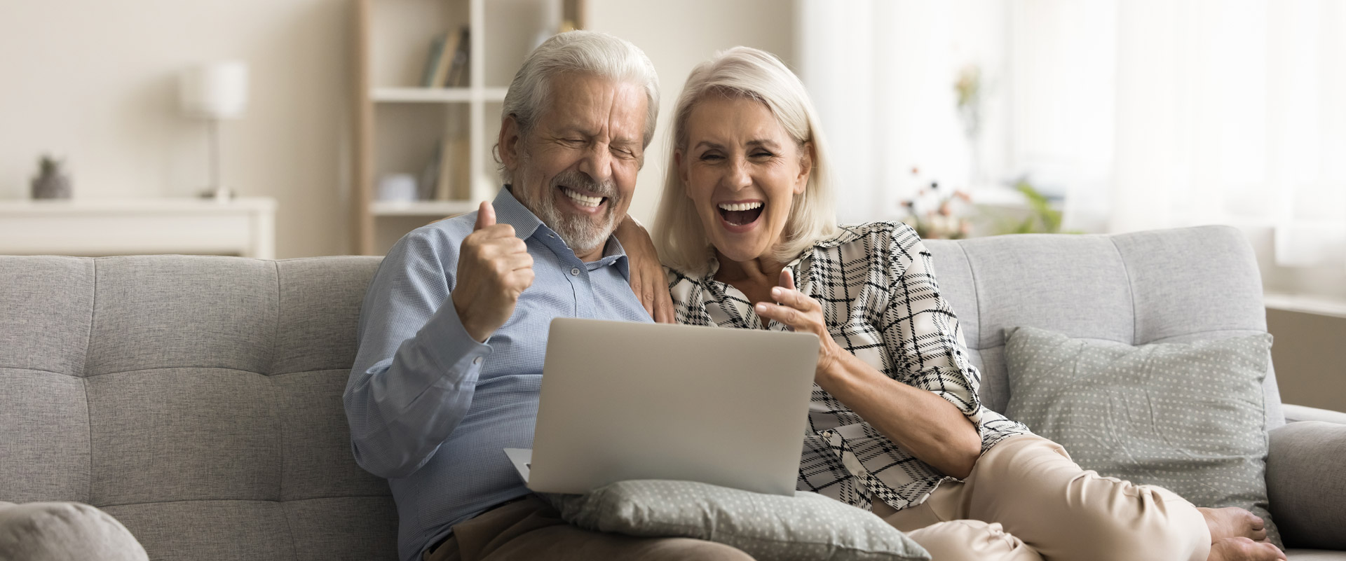 Happy senior couple rejoicing over good news about purchasing their dream house, showcasing their excitement.