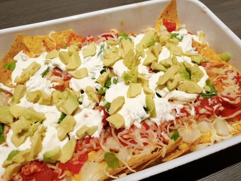 Nachos out of the oven with cheese, tomato and vegetables