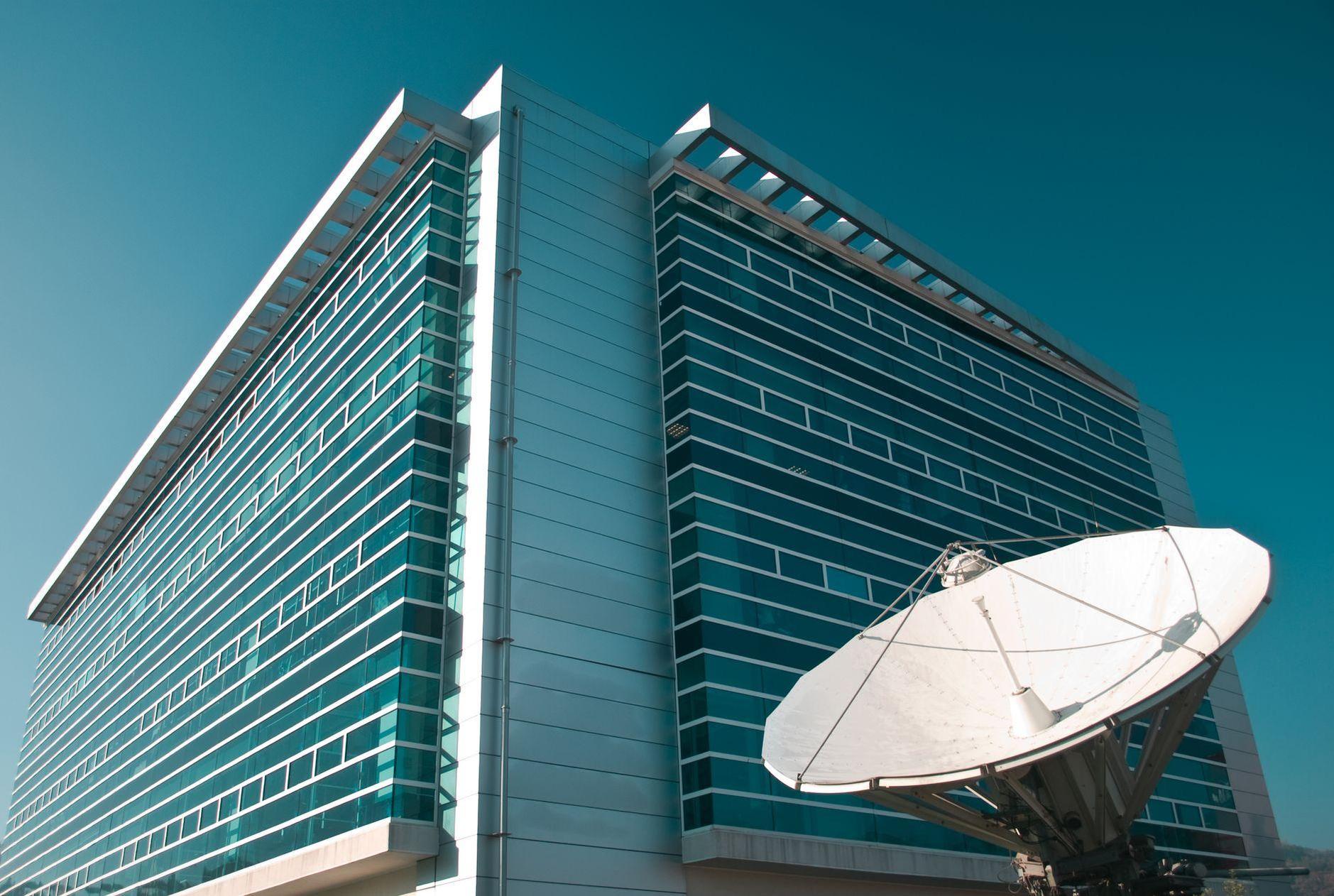 General visual reference for Early Career and Joining KBS. Source: Pexels / Photo by Claudio Salas / Pexels License / https://www.pexels.com/photo/satellite-dish-beside-glass-building-under-blue-sky-14688683/