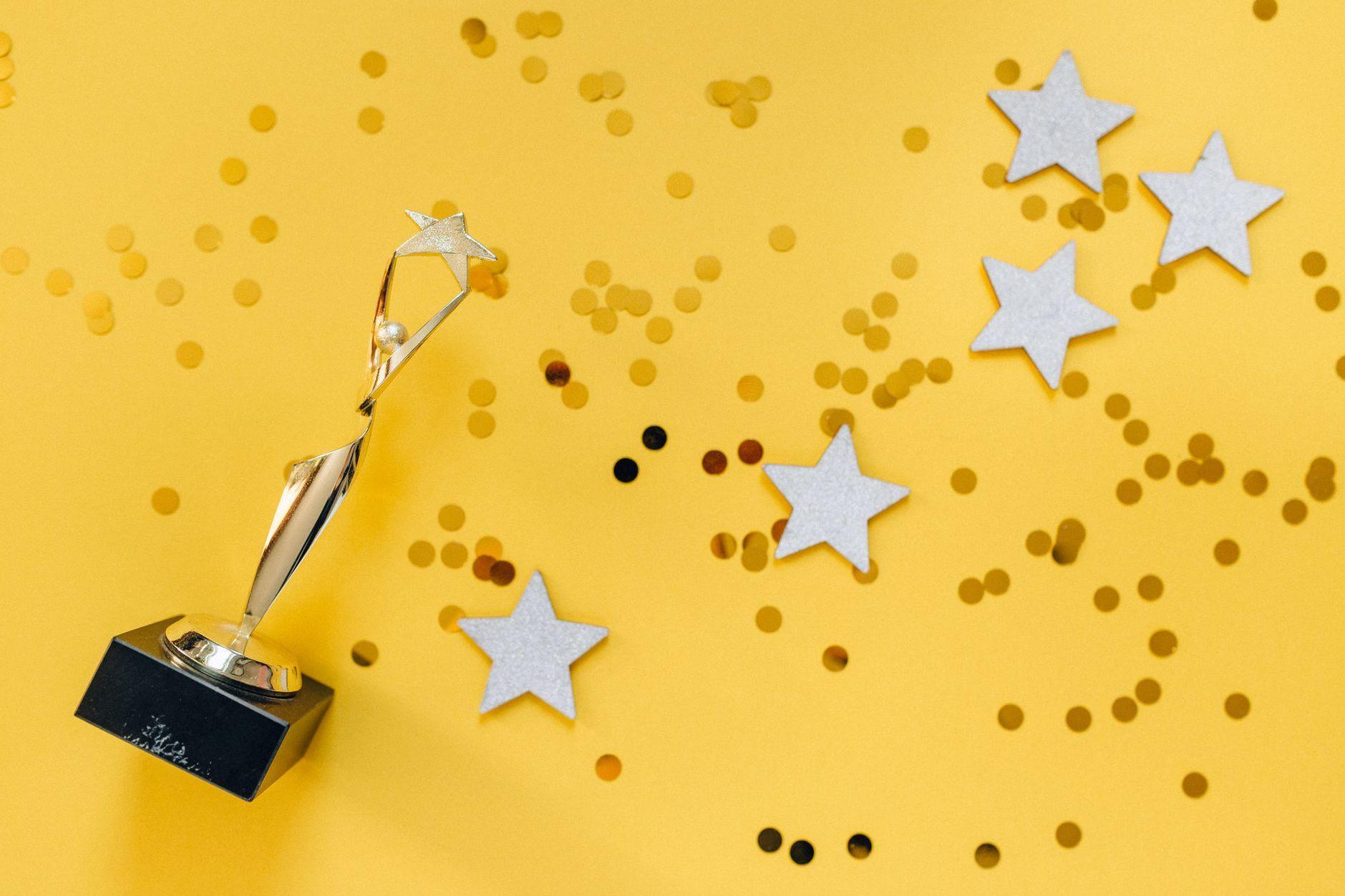 General visual reference for Awards and Critical Recognition. Source: Pexels / Photo by Nataliya Vaitkevich / Pexels License / https://www.pexels.com/photo/golden-statuette-and-stars-on-yellow-background-6532373/