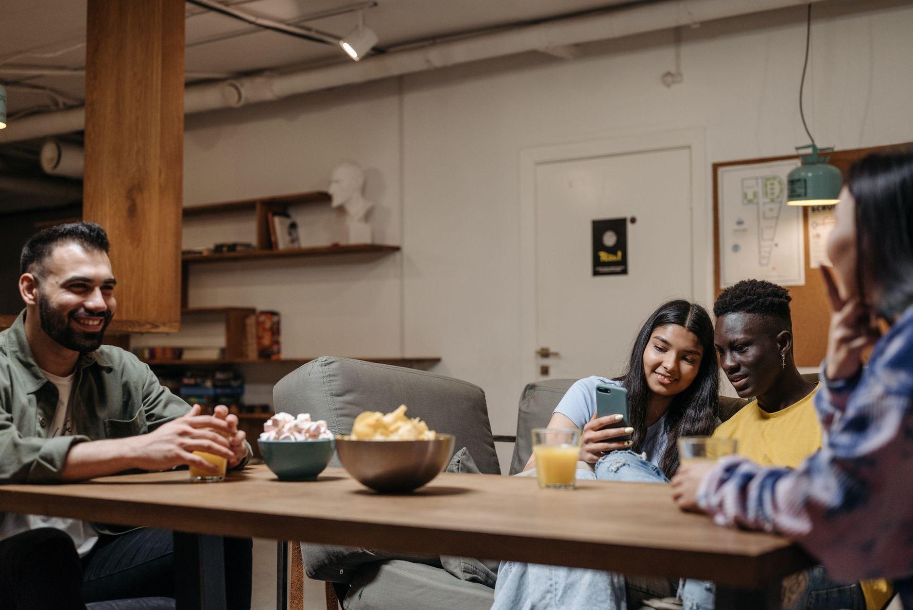 General visual reference for Psychological Resonance of Cynical Humor. Source: Pexels / Photo by Pavel Danilyuk / Pexels License / https://www.pexels.com/photo/smiling-friends-sitting-by-table-with-food-8111297/