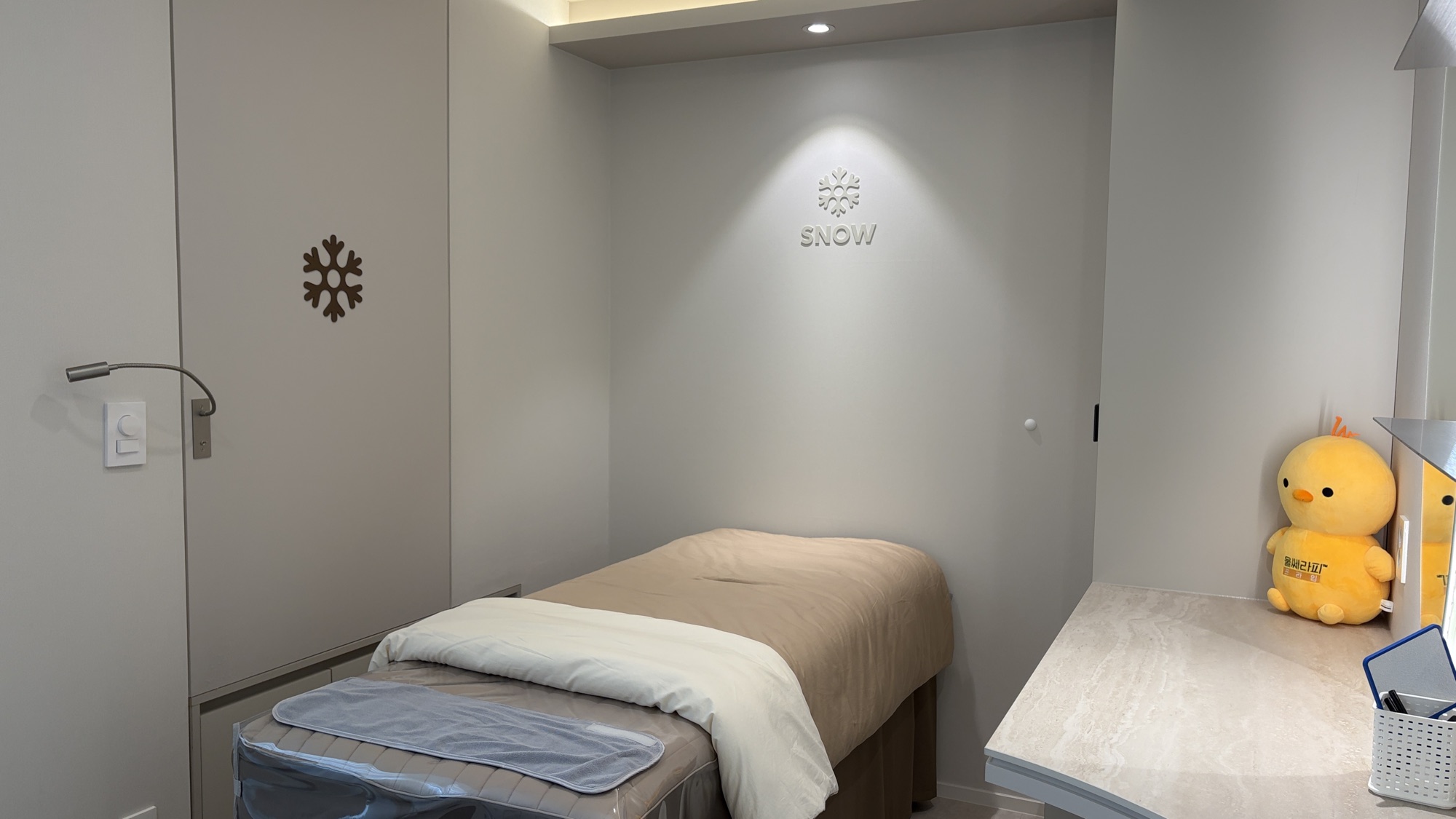 Treatment room bed beneath the clinic's snowflake wall emblem