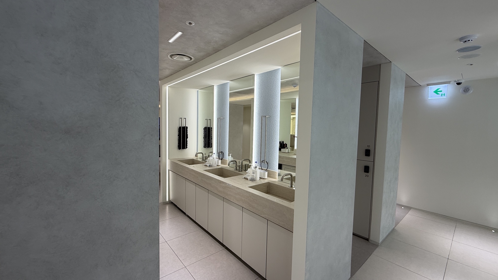 Powder room with a long mirror and twin washbasins