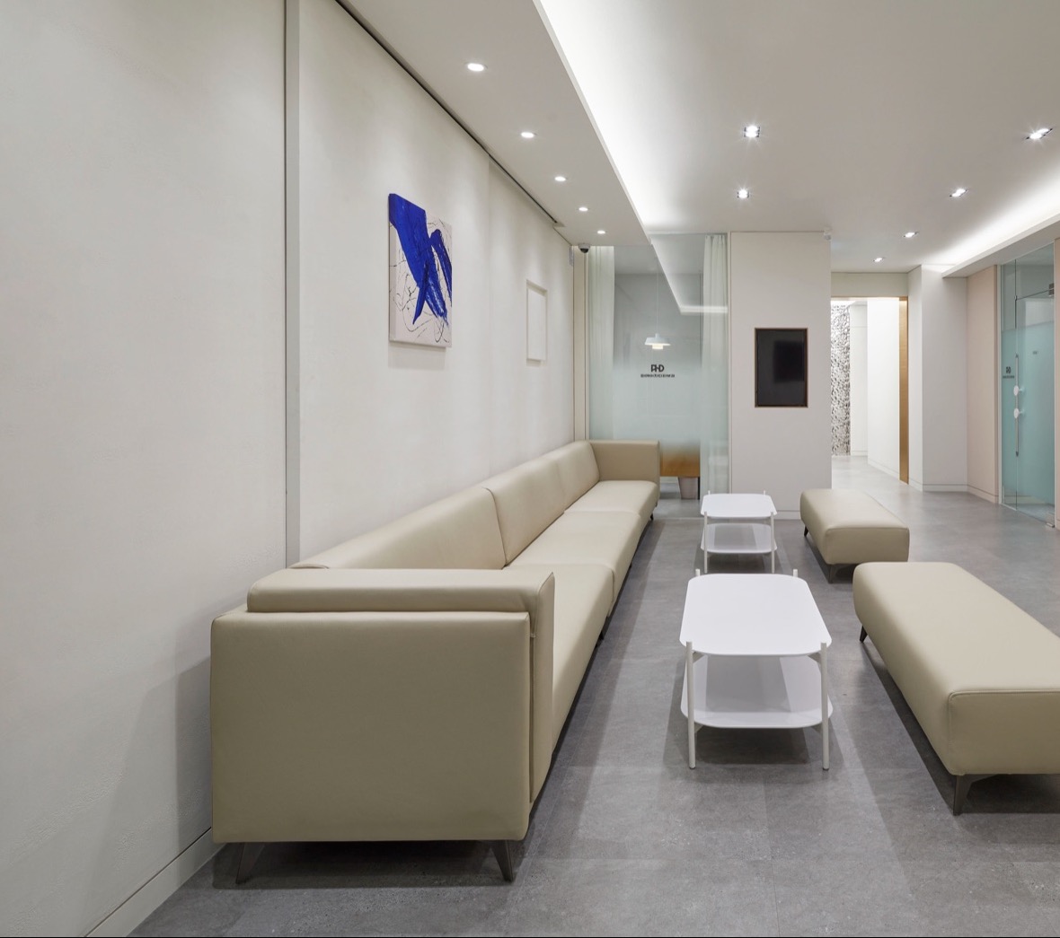 Waiting area with a long sofa and wall artwork