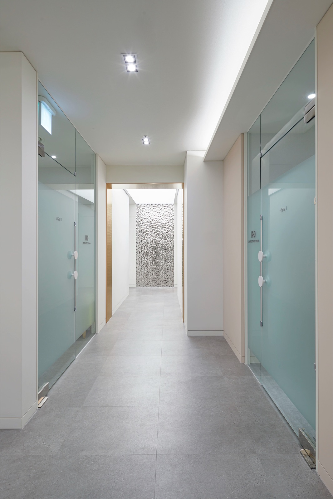 Hallway between two frosted-glass consultation rooms